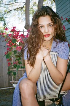 a woman with long hair sitting in a chair