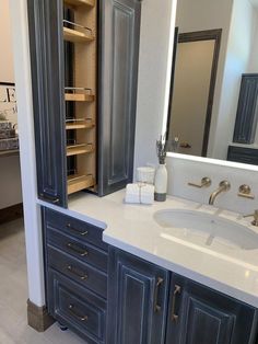 a bathroom with two sinks and cabinets in it