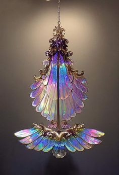 a chandelier hanging from the ceiling with purple and blue glass wings on it