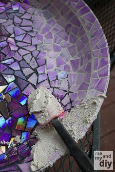 a broken glass plate sitting on top of a metal fence next to a brick wall