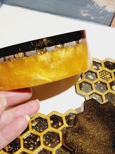 a person is holding a piece of food in their hand next to some honeycombs