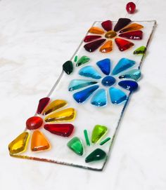 a colorful stained glass piece sitting on top of a white countertop next to a red ball