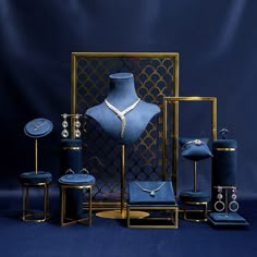 a blue display case with jewelry on it and other items in front of the mannequin