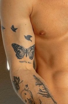 a man with a butterfly tattoo on his arm and chest is looking at the camera