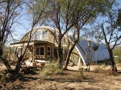 the house is surrounded by trees and dirt