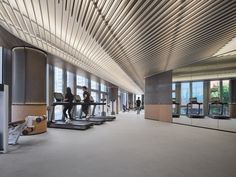 people are sitting on treadmills in an office building with large windows overlooking the city