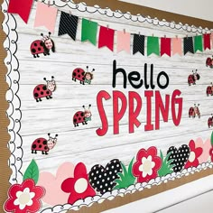 a bulletin board that says hello spring with ladybugs and flowers on the front