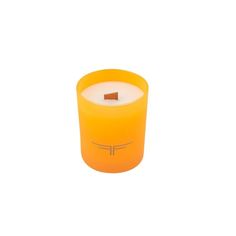 an orange candle is sitting on a white surface