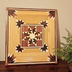 a wooden frame sitting on top of a table next to a potted plant