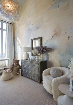 a bedroom decorated in pastel tones with teddy bears on the dresser and other furniture