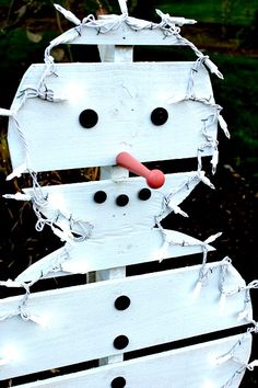 a snowman made out of white boards with black dots