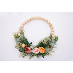 a wooden beaded necklace with flowers and greenery