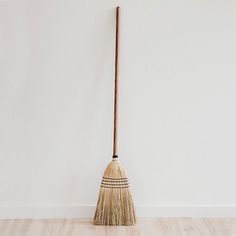 a broom leaning up against a white wall