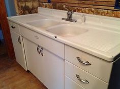 an old fashioned kitchen sink with two faucets on the bottom and drawers below