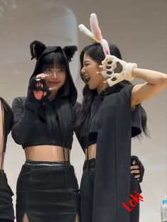 two women dressed in costumes posing for the camera with their hands on their hipss