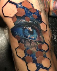 a man's arm with an eye and hexagons on it