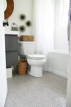 a white toilet sitting in a bathroom next to a window