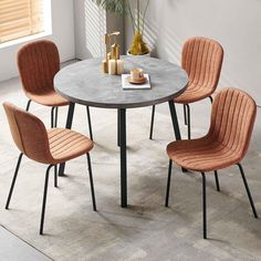 a table with four chairs around it and a plant in the corner next to it