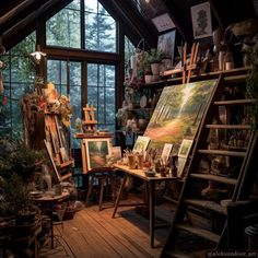 an artist's studio with lots of paintings and plants