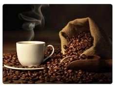 a cup of coffee sitting on top of a pile of coffee beans