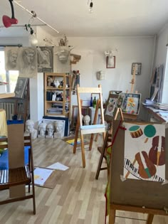 an artist's studio with several easels and paintings on the walls in front of them