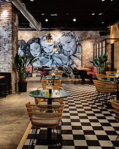 the interior of a restaurant with checkered flooring and large murals on the wall