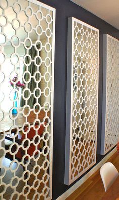 a woman sitting at a table in front of a window with decorative screens on it