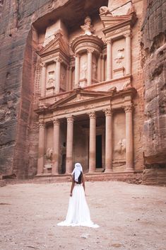 a woman standing in front of an ancient building