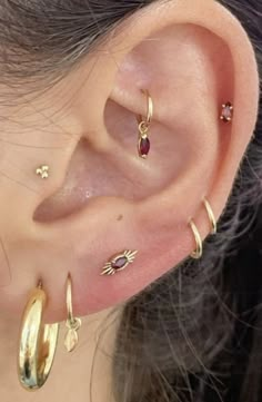 a close up of a person's ear with three different types of piercings