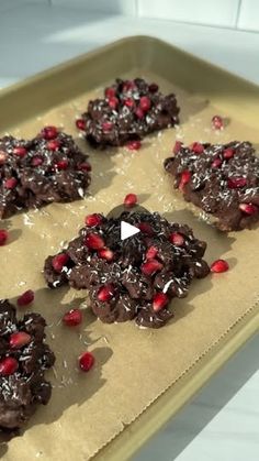 cookies with chocolate and pomegranates are on a baking sheet, ready to be baked