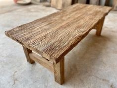 a wooden bench sitting on top of a cement floor