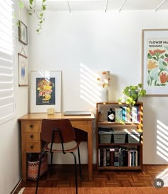 a chair and desk in a room with wood flooring, white walls and windows