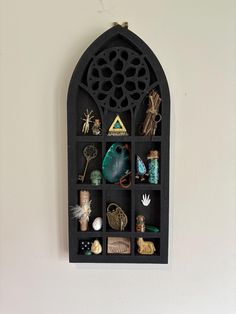 a black shelf with various items on it and a white wall in the back ground