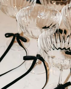 several wine glasses are lined up on a table with black ribbon around them and one is empty