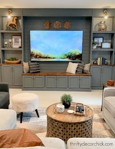 a living room filled with furniture and a flat screen tv mounted on a wall above a fireplace