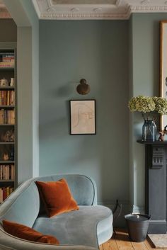 a living room filled with furniture and a fire place next to a book shelf full of books