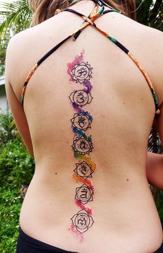 the back of a woman's body with seven chakras painted on it