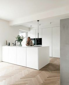 a woman is standing at the kitchen counter