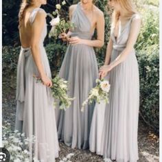 three bridesmaids in long gray dresses standing next to each other