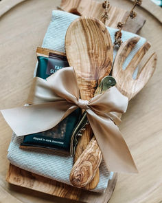 wooden utensils and spoons wrapped in ribbon sit on top of napkins