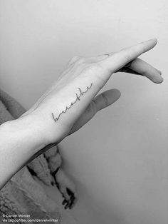 a person's hand with the word love tattooed on it