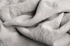 a close up view of a gray linen material that has been folded in several different directions