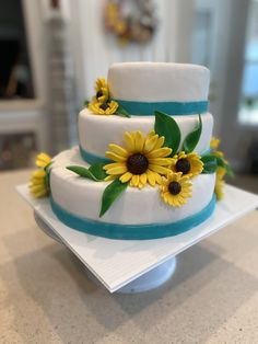 a three tiered cake with sunflowers on it