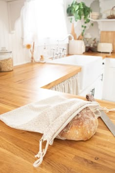 a loaf of bread sitting on top of a kitchen counter next to a knife and cloth