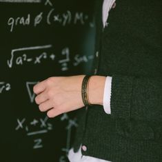 a close up of a person's hand near a blackboard