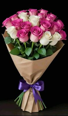 a bouquet of pink and white roses wrapped in brown paper with purple ribbon on black background