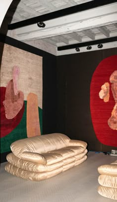 there are many pieces of art on display in this room, including pillows and rugs