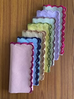 five different colors of cloths on a wooden surface