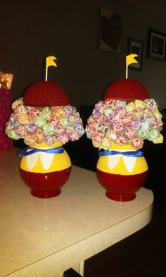 two red vases with flowers on them sitting on a counter