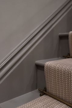 a cat sitting on top of a carpeted stair case next to a hand rail